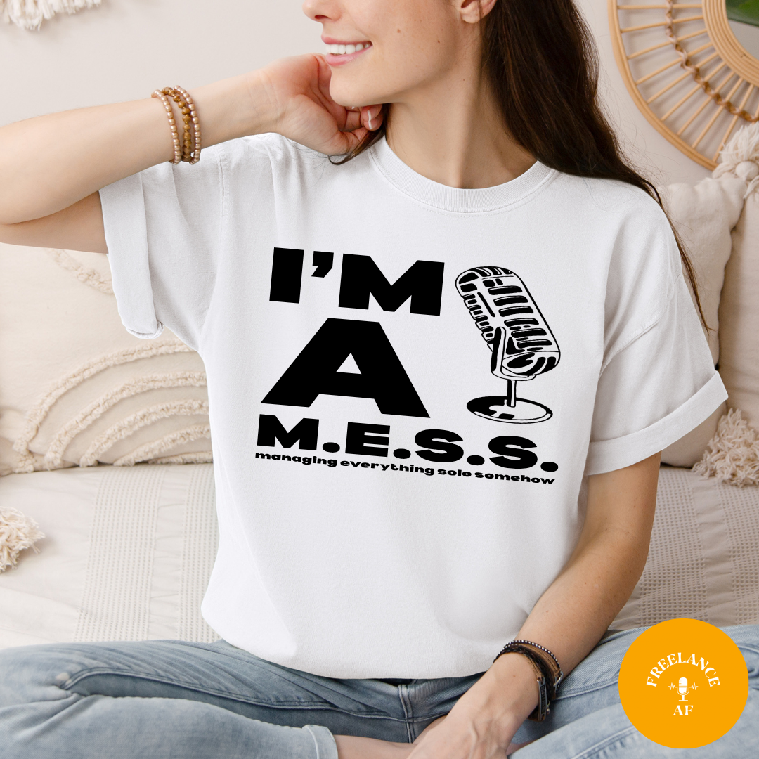 Woman wearing a white I’m a M.E.S.S. freelancer T-shirt meaning Managing Everything Solo Somehow