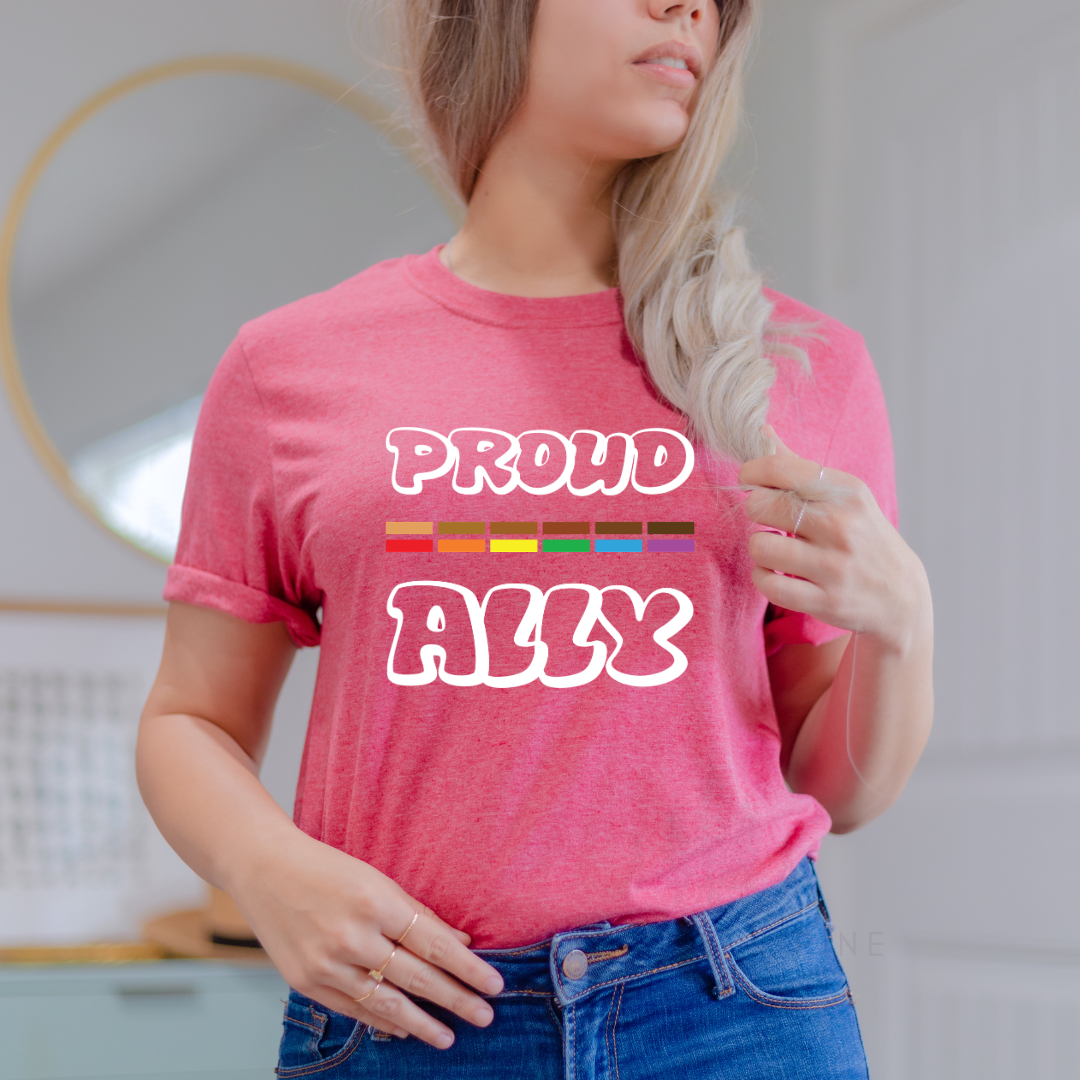 person wearing red proud ally pride shirt with bold rainbow text design