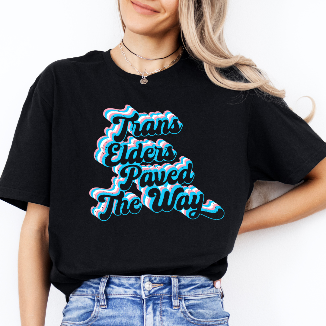 person wearing black trans elders paved the way pride shirt with retro text design