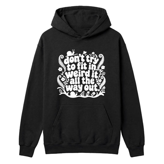 A black pullover hoodie with a white graphic text print on the chest that reads 'don't try to fit in weird it all the way out' surrounded by decorative fern and floral illustrations, shown on a plain white background.