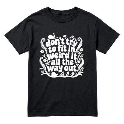 A black short-sleeve crewneck t-shirt with a white graphic print on the front that reads 'don't try to fit in weird it all the way out' in a decorative hand-lettered style with small floral and leaf illustrations.