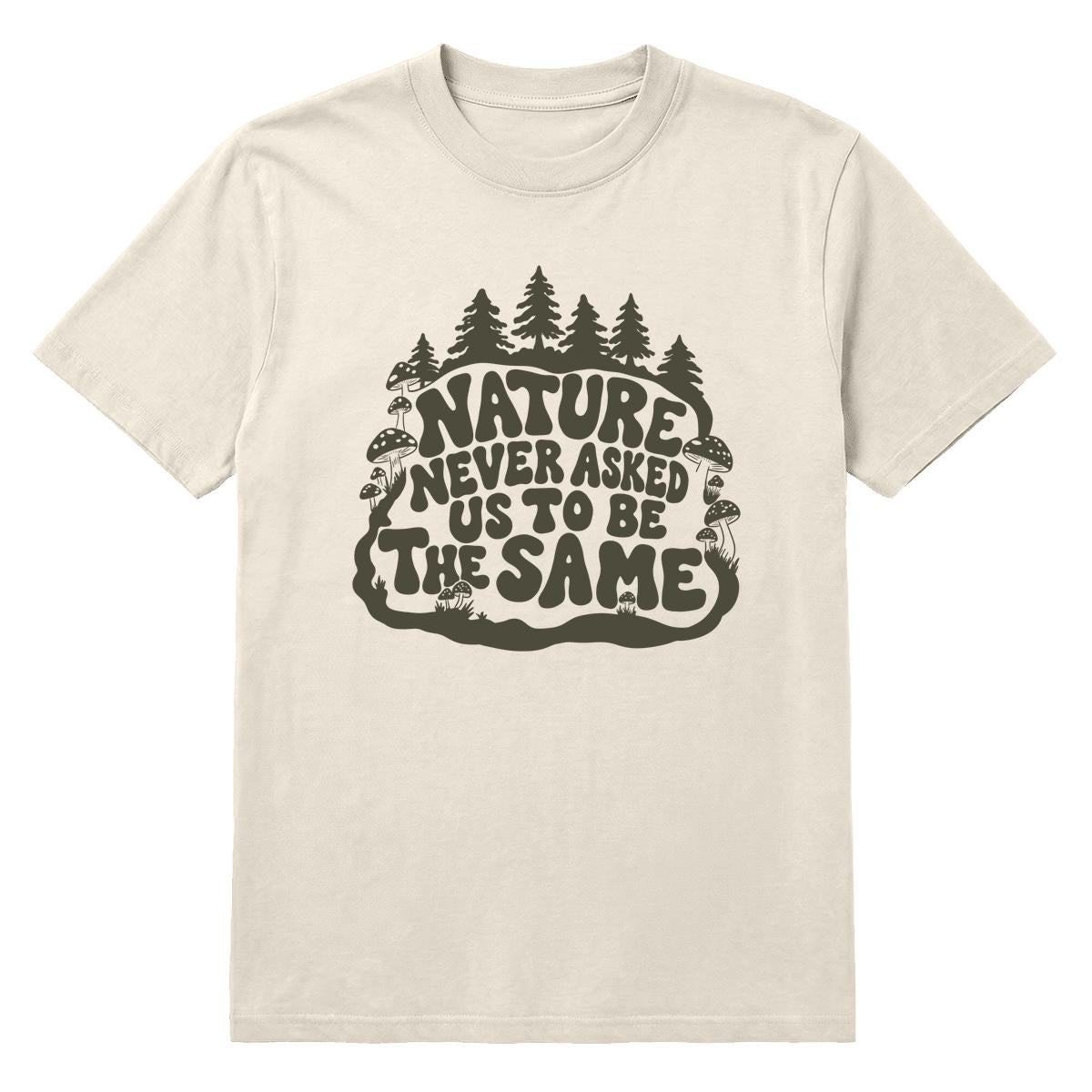 An off-white crewneck t-shirt featuring a dark olive green graphic on the front with the text 'NATURE NEVER ASKED US TO BE THE SAME' surrounded by pine trees and mushrooms.
