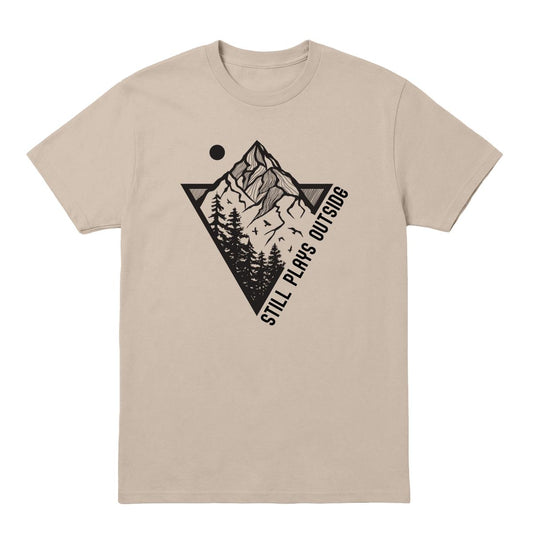 Sand T-shirt with mountain and pine tree graphic and “Still Plays Outside” text