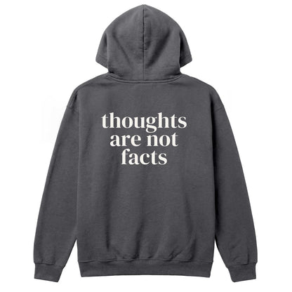 Back of charcoal hoodie with large “Thoughts Are Not Facts” text