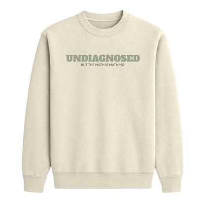 Sand crewneck sweatshirt with “Undiagnosed But the Math Is Mathing” text in sage green and black