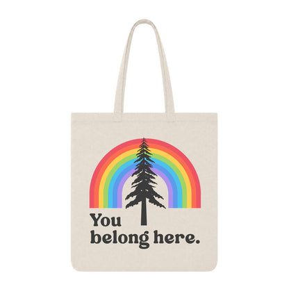 Natural tote bag with rainbow and pine tree graphic and “You Belong Here” text