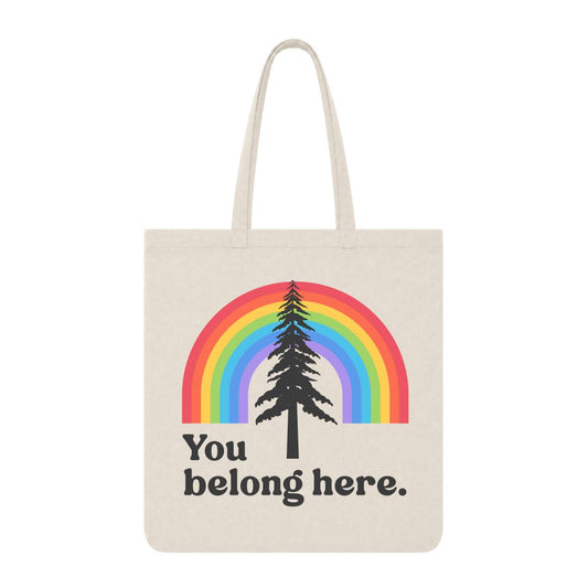 Natural tote bag with rainbow and pine tree graphic and “You Belong Here” text